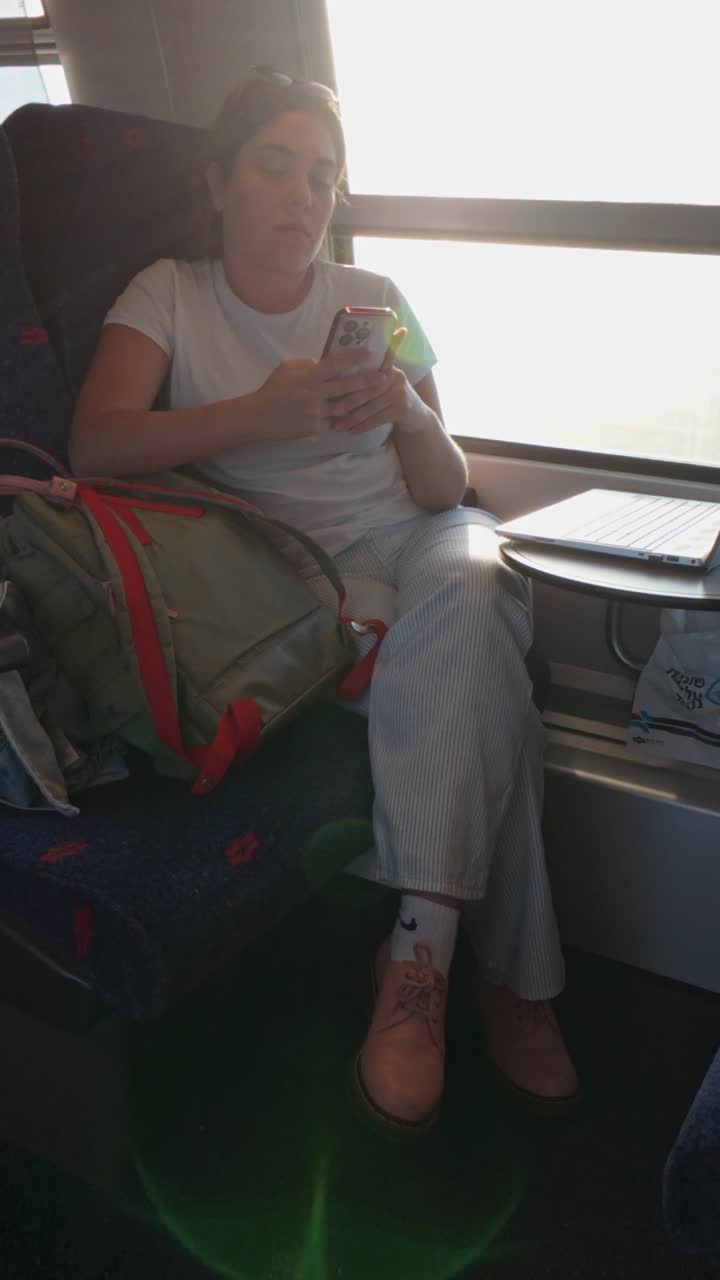 A Traveler Candid Moment with Her Smartphone on a Train