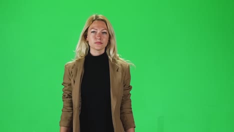blonde girl in black turtleneck jeans and sneakers going against green screen blonde girl in black turtleneck jeans and sneakers going and looking straight into the camera against a green screen slender girl with bright eyes focused