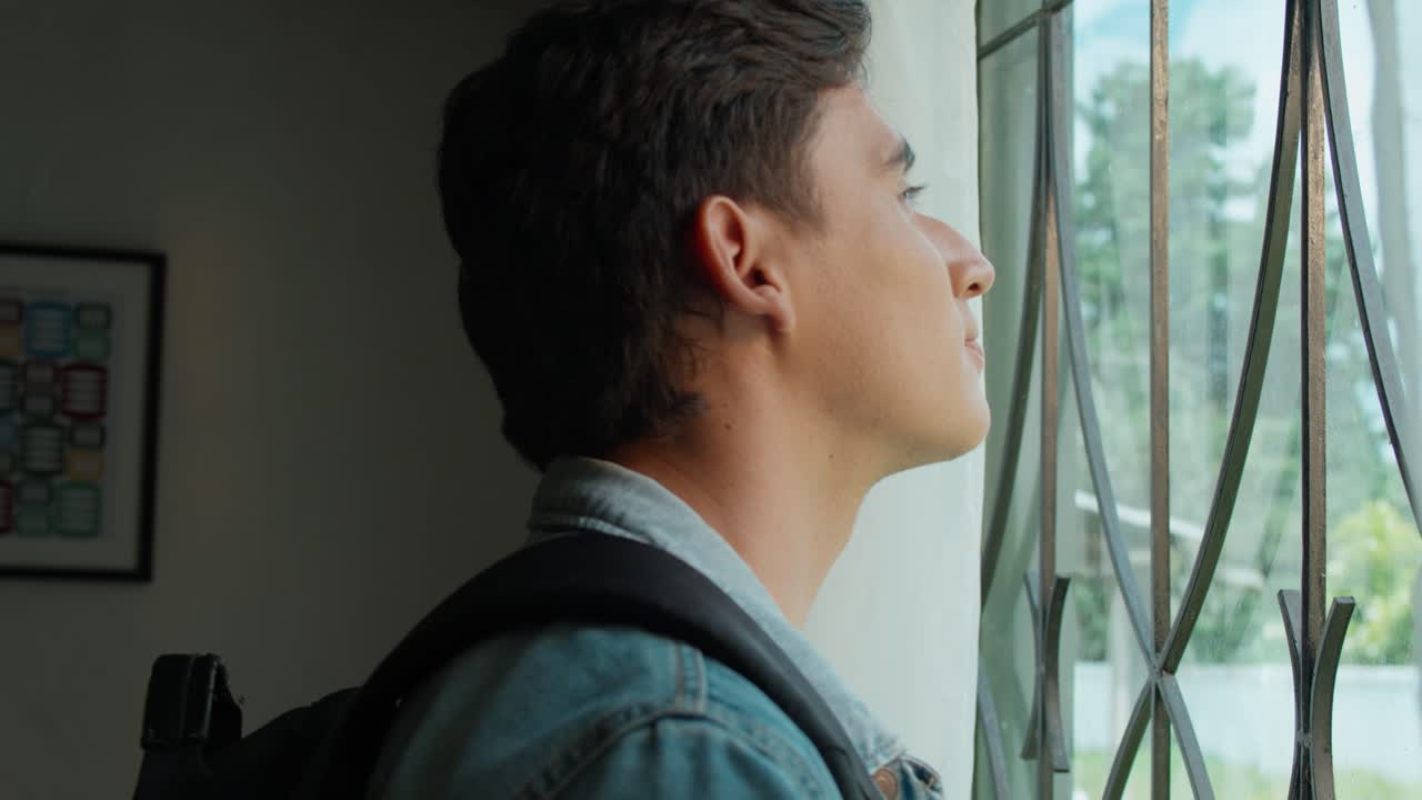 A student imagines his future by a glass window before leaving for college