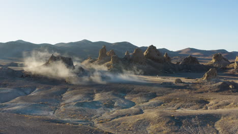 cinematic establishing shot of the trona pinnacles covered with dust overlooking mountain range