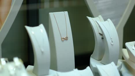 hay pendientes de oro y joyas en la ventana de la joyería jwe