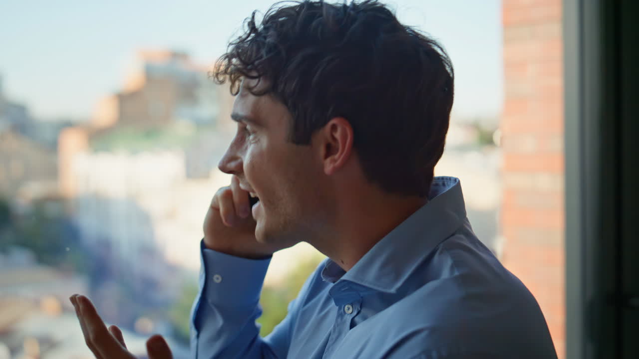Worried manager arguing mobile phone standing at office panoramic window closeup