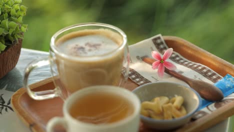 tray of hot drinks and a snack with a flower