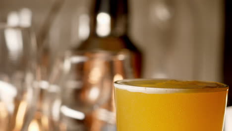 close up of craft beer being poured in to a pint glass, light background off center, with copy space