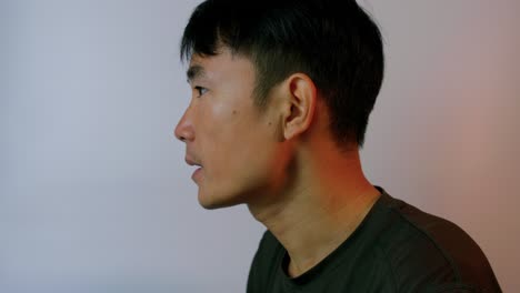 close up of young asian man drinking coconut water with straw from a green exotic coconut