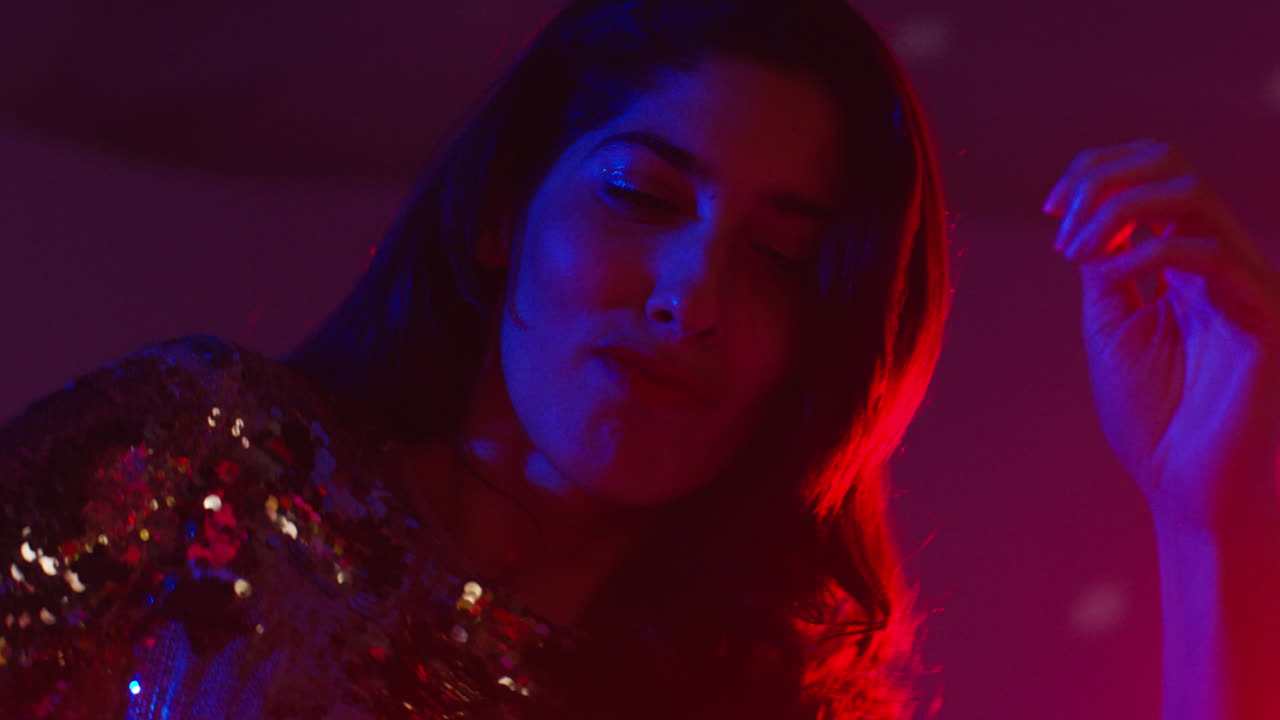 primer plano de una mujer en un bar nocturno o discoteca bailando con luces brillantes 8