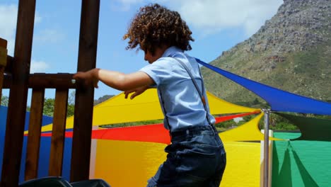 Vista-Lateral-De-Una-Colegiala-De-Raza-Mixta-Jugando-En-El-Patio-De-La-Escuela-En-Un-Día-Soleado-4k