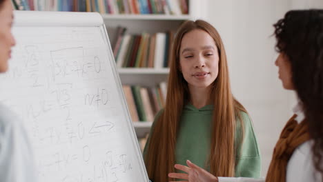 students discussing math problems on a whiteboard