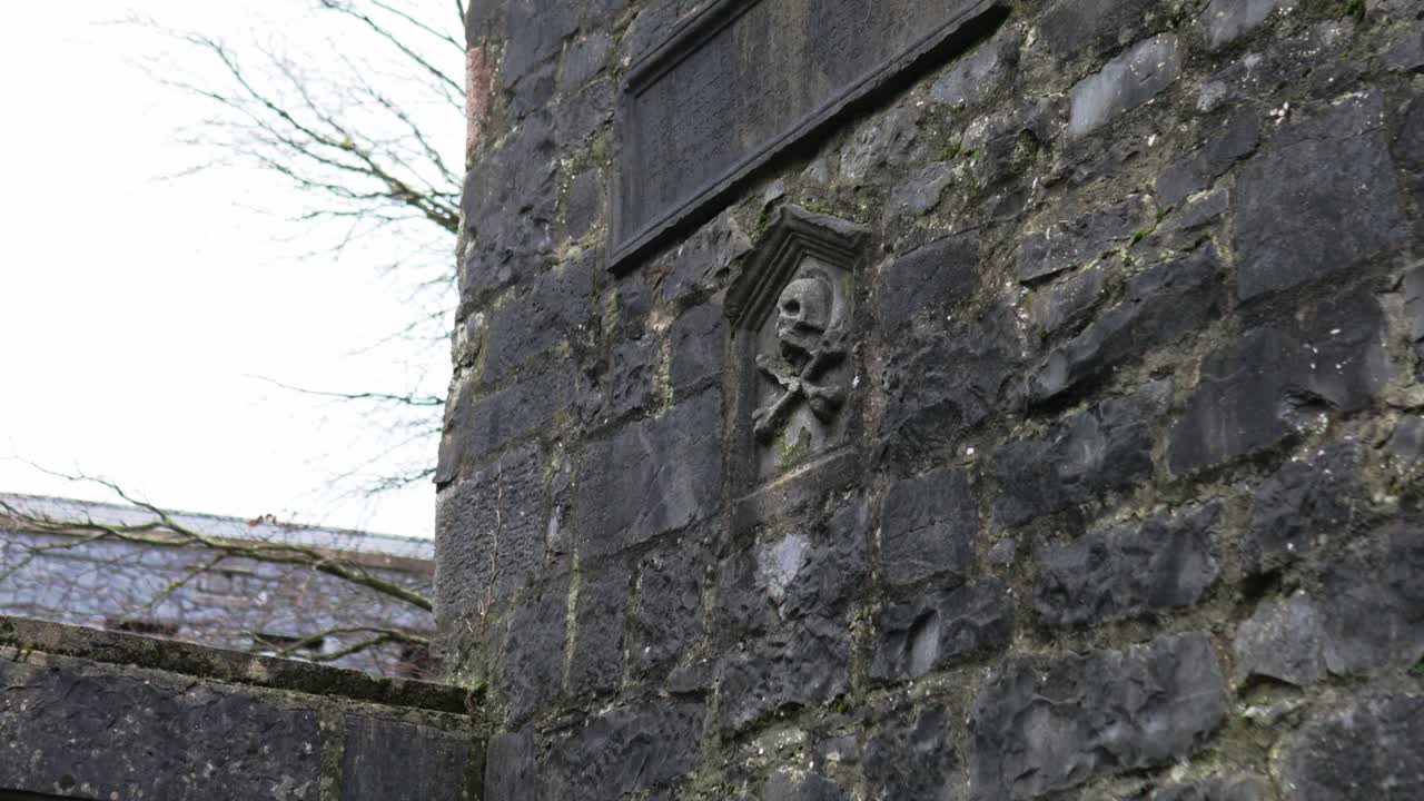 Parede exterior da Janela Memorial de Lynch em Galway City, um monumento medieval construído com alvenaria de calcário e detalhes arquitetónicos góticos