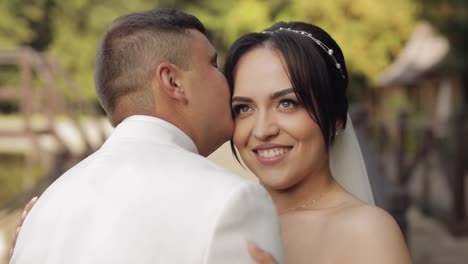 newlyweds, caucasian groom with bride walking, embracing, hugs in park, wedding couple in love