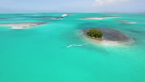 cavaliere uomo che vola sull'acqua del mare caraibico piatto, arcipelago di kitesurf los roques