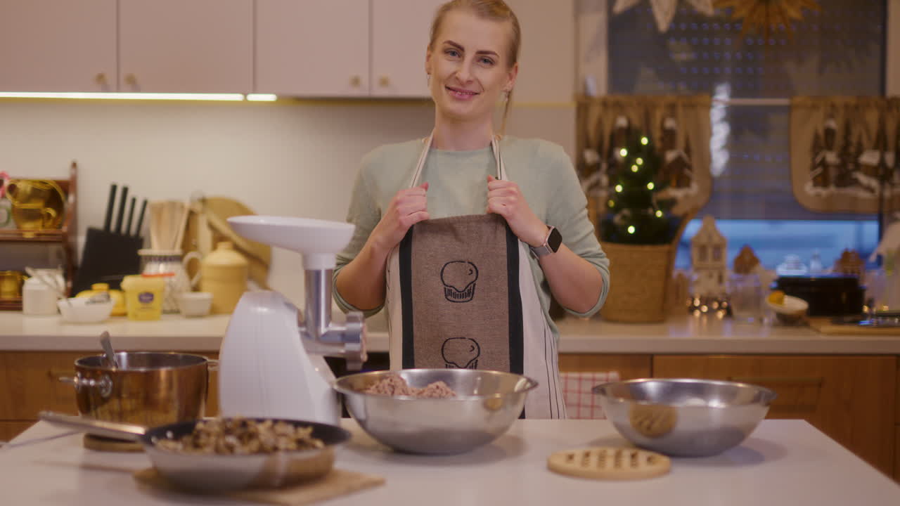 mujer sonríe en el fondo de la cocina mientras trabaja preparando platos de vacaciones