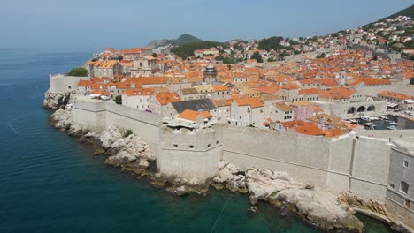 un dron aéreo gira sobre la antigua fortaleza a lo largo del casco antiguo de dubrovnik, croacia, con vistas a los tejados de los edificios en un día soleado