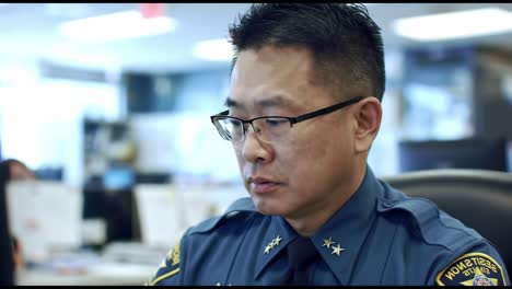 focused officer analyzing reports in a modern law enforcement office environment, showcasing commitment to public safety and detail-oriented work ethic