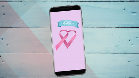 Animation-of-pink-breast-cancer-ribbon-logo-with-breast-cancer-text-on-smartphone-screen