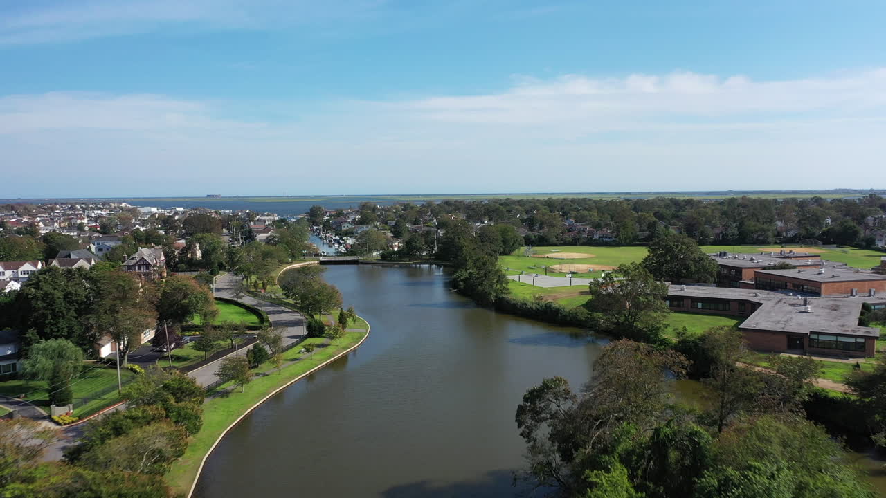 un dron aéreo disparó sobre un estanque verde en un barrio suburbano en long island, nueva york