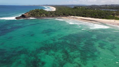 turquoise sea and sandy beach of fingal head with view of headland and causeway in new south wales, australia. aerial shot