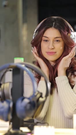 woman trying on headphones in electronics store. high quality fullhd footage