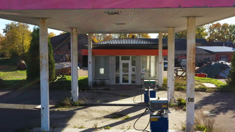 abandoned rural aral diesel gas station with overgrown surroundings and empty fuel pumps