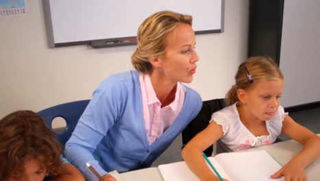 Profesor-Ayudando-A-Los-Niños-Con-Sus-Tareas-En-El-Aula.