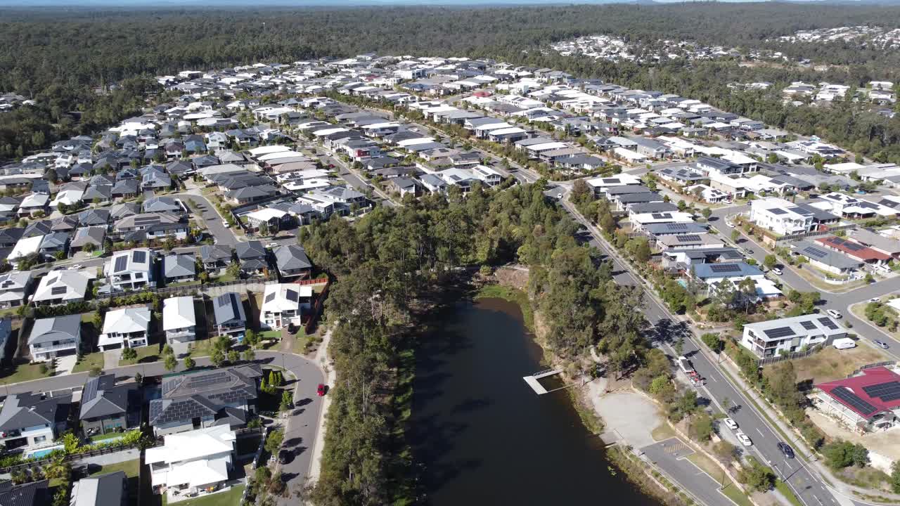 vista aérea de un denso suburbio residencial australiano que muestra parte de un lago artificial