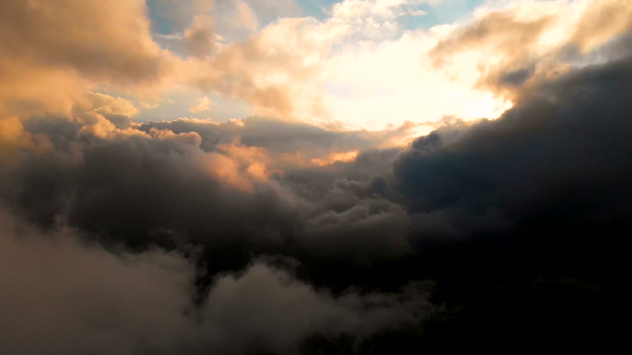 la cámara se extiende a través de las nubes de lluvia de la noche al atardecer por encima de los niveles de nubes. fabuloso vuelo en las nubes. vista aérea