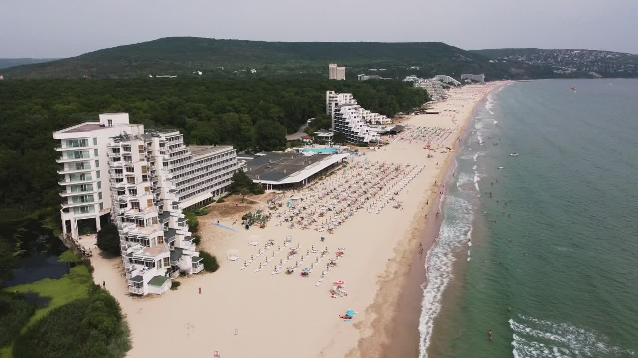 Aerial drone shot of Albena, a major Black Sea resort in northeastern Bulgaria, showcasing its beaches, resorts, and surrounding landscape, offering view of coastal area's beauty and tranquility.