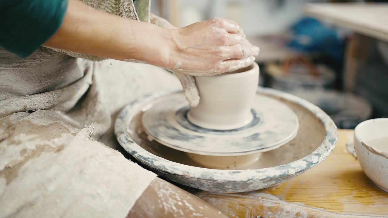 도자기 수업: 여성이 회전 바에 도자기를 만들고, 점토에 물을 첨가하고, 느린 동작, 추적