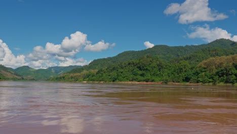 slow boat cruise on mekong river, beautiful panorama, colorful reflection on water