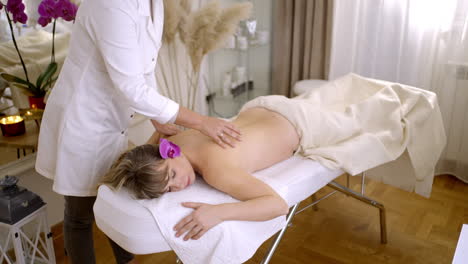 una mujer recibiendo un masaje de espalda en un spa.