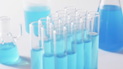 Video-of-glass-laboratory-test-tubes-with-blue-liquid-with-copy-space-on-white-background