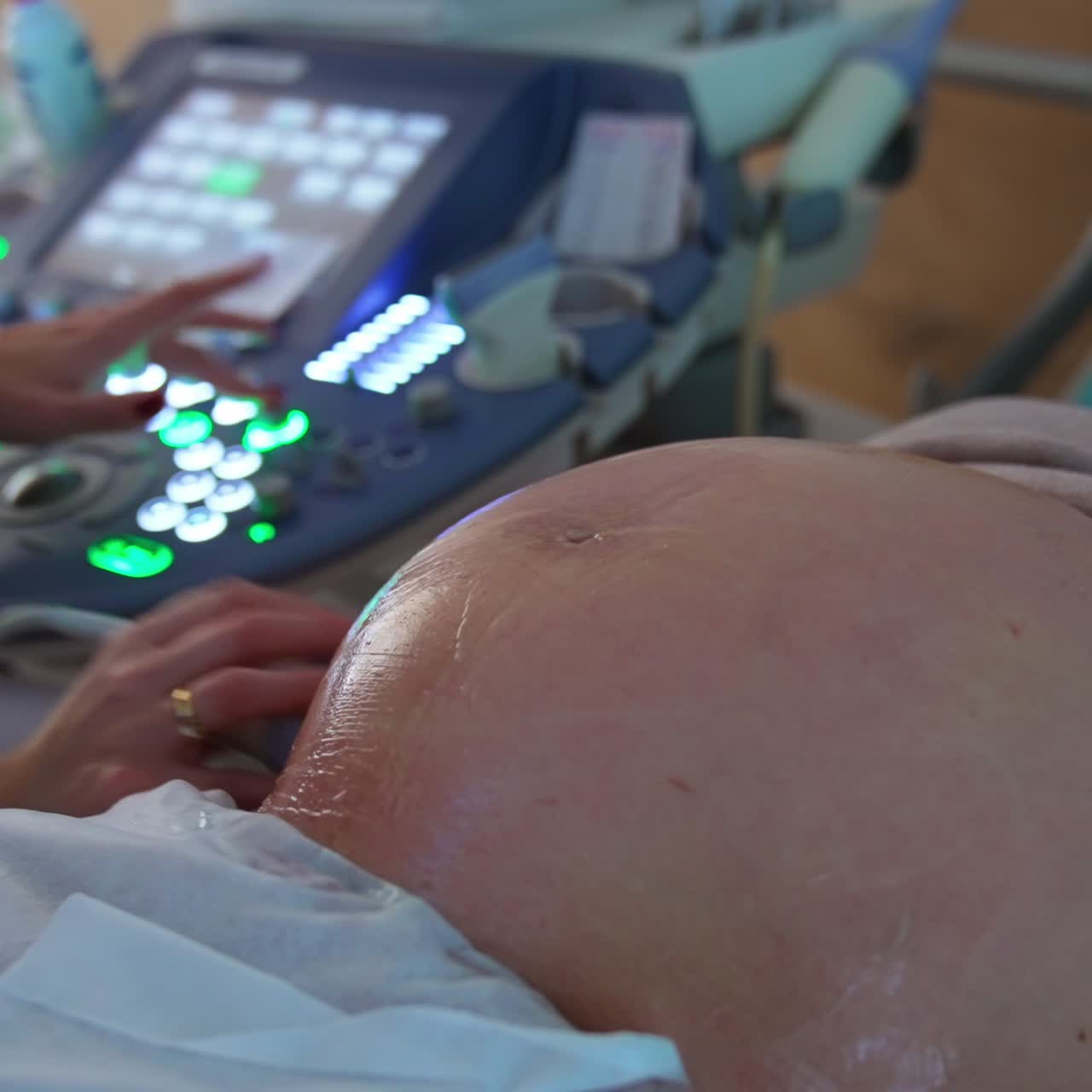 Grosso addome coperto di gel di una donna incinta. Il medico esegue un'ecografia a una futura mamma negli ultimi mesi di gravidanza.