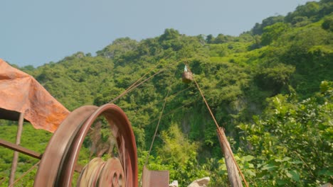 Low-angle-shot-of-ropeway-transporting-ripe-sugar-apple-fruit-from-hilltop-in-Chi-Lang-district,-Lang-Son-province,-Vietnam-at-daytime-1