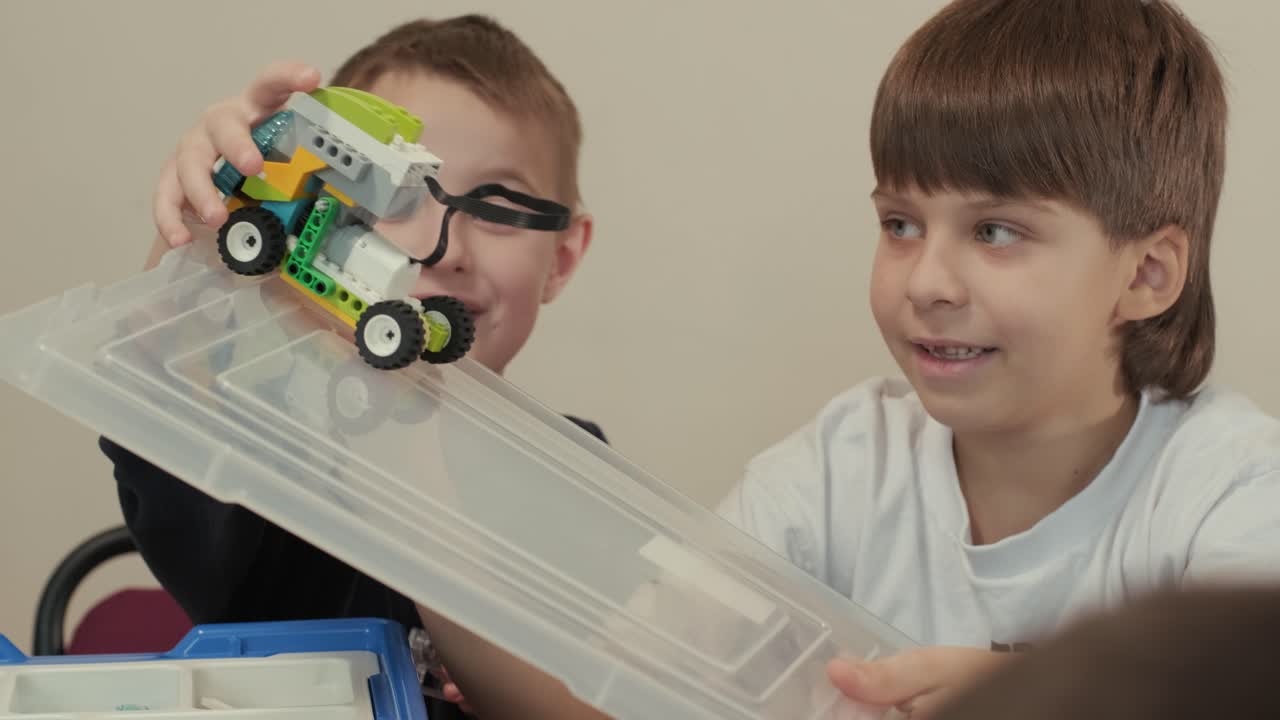 los niños participan en actividades de aprendizaje básico, montando kits de robótica con enfoque y trabajo en equipo en un entorno de aula