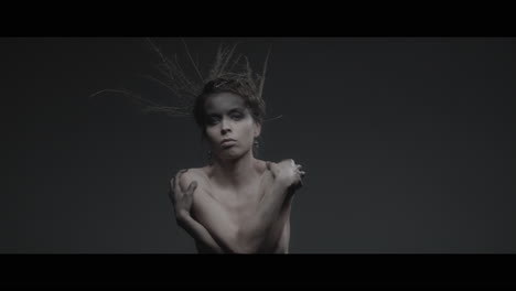 a woman dressed as mother nature moves slowly in a dance-like motion