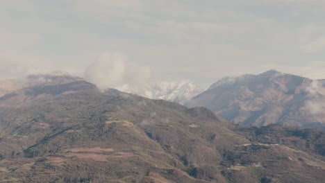 mountains veiled in delicate, misty clouds in cusco, peru - aerial drone shot