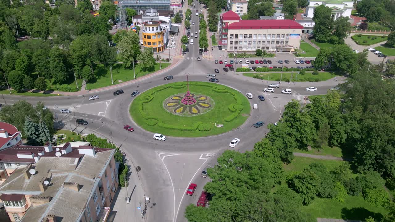 4к воздушный вид круговой дороги с круговыми автомобилями в небольшом европейском городе в солнечный день