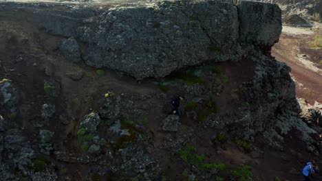 Vista-Aérea-De-Dos-Escaladores-Por-El-Camino-De-Una-Colina-En-Islandia.-Vista-De-Drones-Vista-De-Pájaro-Dos-Personas-Excursionistas-Bajando-Del-Acantilado