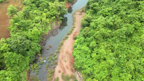 Drohne-Folgt-Kanal-Im-Grünen-Wald-In-Konkan