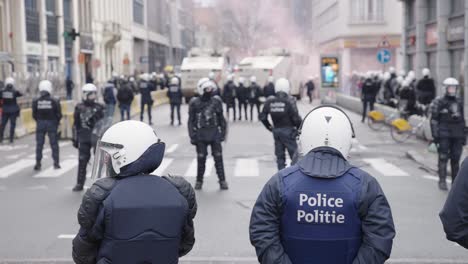 belgian police line both sides of the street in full riot gear during protest, slow motion