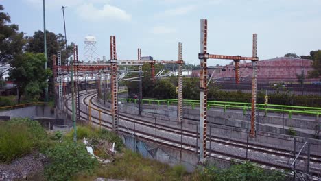 car passing next to neglected urban train tracks, a water tank can be seen in the background