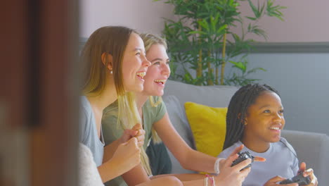 group of teenage girl friends gaming and hanging out in bedroom at home