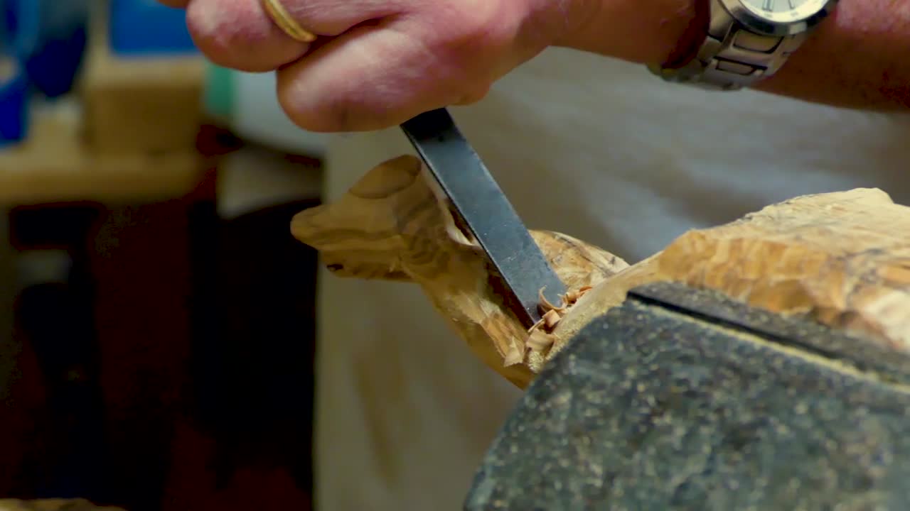 escultor italiano en su taller trabajando en una estatua de madera de olivo