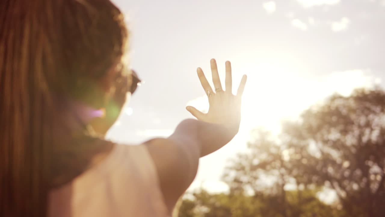 아들을 바라보며 손으로 아들에게서 자신을 숨기는 여자의 가까운 뒷면. 드레드를 가진 젊은 여성이 놀고 있습니다.
