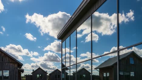stunning reflection of a modern structure amidst rustic buildings and a beautiful sky, capturing the tranquility of nature's beauty in harmonious design