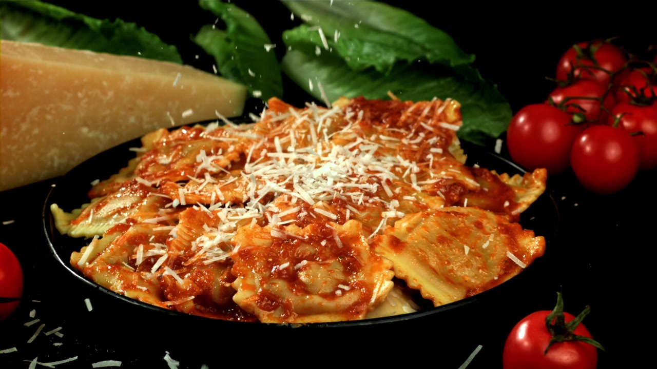 Parmigiano che Cade al Rallentatore su Ravioli con Salsa di Pomodoro