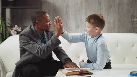 black tutor gives high five and shows thumb-up to student