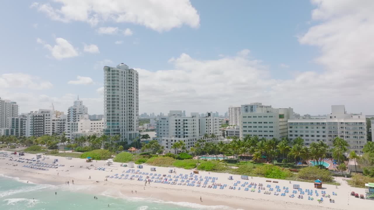 modernos edificios de apartamentos de varios pisos u hoteles en la costa del mar. revelación al revés de una playa de arena con tumbonas. miami, ee.uu.