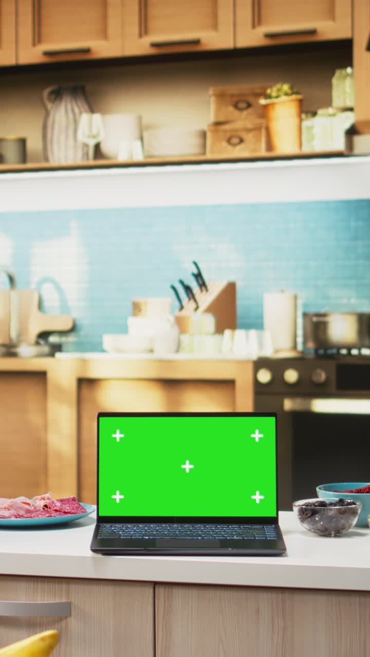 Vertical Video Green screen on a laptop placed on empty table in rustic kitchen space