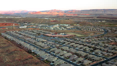 aerial view of a residential community nestled against desert mountains at sunset